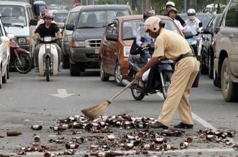 Cảnh s&aacute;t Giao th&ocirc;ng dọn mảnh vỡ chai bia tr&ecirc;n một tuyến phố đ&ocirc;ng người. (Nguồn: Facebook).