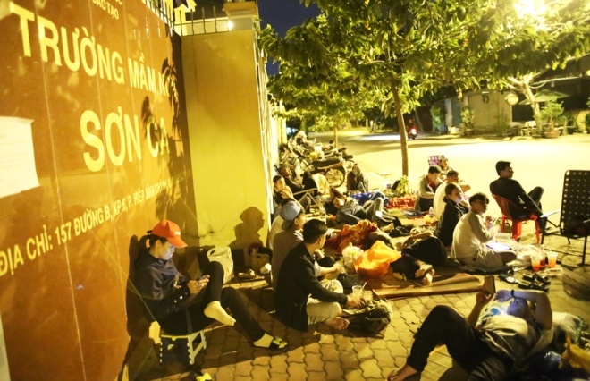 Phụ huynh nằm la liệt trước cổng trường để mong con c&oacute; một suất học tại trường Sơn Ca. (Ảnh: VnExpress)