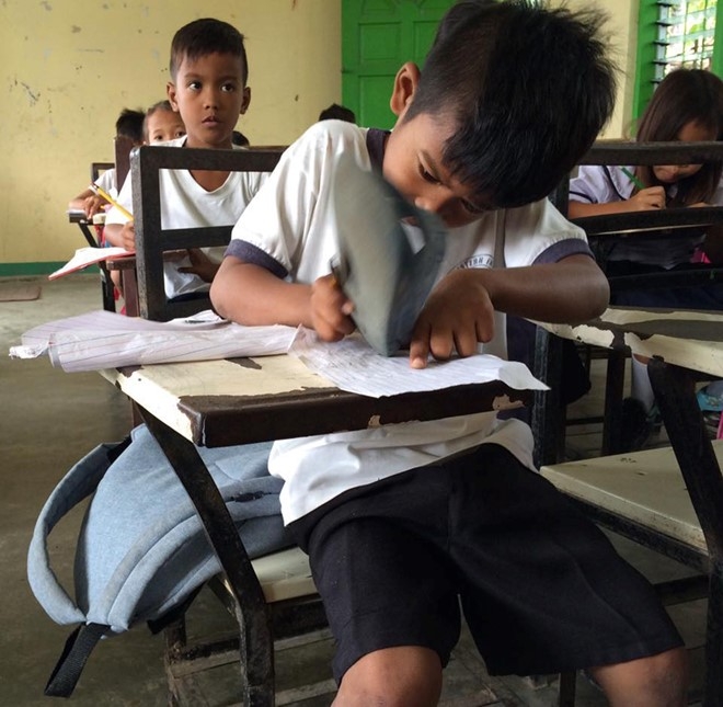 Harold d&ugrave;ng d&eacute;p để tẩy v&igrave; kh&ocirc;ng c&oacute; đủ đồ d&ugrave;ng học tập. Ảnh: Rosalie Dela Cruz.