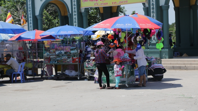 Ngay cổng v&agrave;o, nhiều người b&aacute;n h&agrave;ng ngồi chễm chệ dưới nền như ở nh&agrave; của m&igrave;nh để mời gọi du kh&aacute;ch mua h&agrave;ng từ v&eacute; số, nhang đ&egrave;n, ảnh Phật B&agrave;, qu&agrave; lưu niệm, d&acirc;y thắt lưng, v&agrave; cả mặc h&agrave;ng thủy hải sản tươi sống như t&ocirc;m, cua, ghẹ.