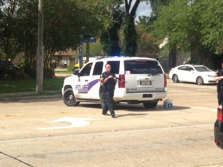 Cảnh s&aacute;t Mỹ cầm s&uacute;ng trường c&aacute;ch hiện trường vụ tấn c&ocirc;ng v&agrave;i t&ograve;a nh&agrave; (Ảnh: Twitter Michael Vinsanau)