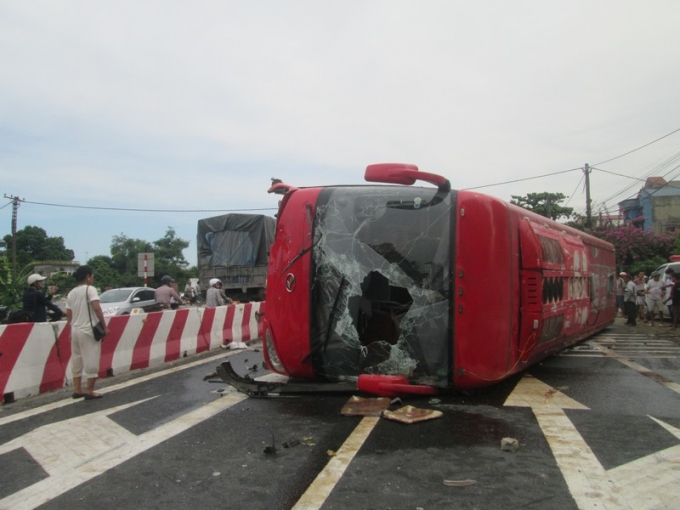 Chiếc xe kh&aacute;ch bị vỡ k&iacute;nh, lật ngang tr&ecirc;n quốc lộ khiến giao th&ocirc;ng bị gi&aacute;n&nbsp;đoạn.