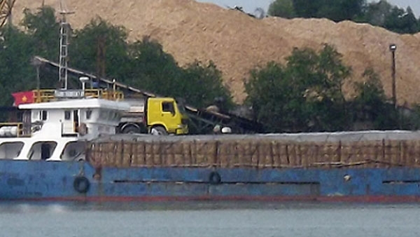 T&agrave;u chở dăm gỗ được phủ k&iacute;n bằng vải bạt chịu nước .