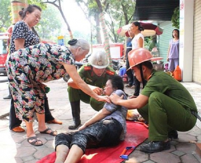 Người phụ nữ bị ngạt kh&oacute;i l&agrave; chủ của ng&ocirc;i nh&agrave; đang được người d&acirc;n v&agrave; lực lượng cứu hỏa sơ cứu.