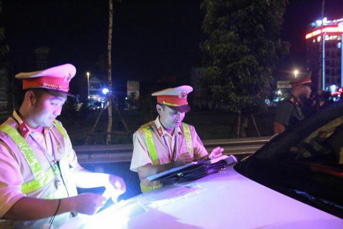 Lực lượng CSGT tiến h&agrave;nh lập bi&ecirc;n bản xử l&yacute; xe tải trở đất vi phạm.