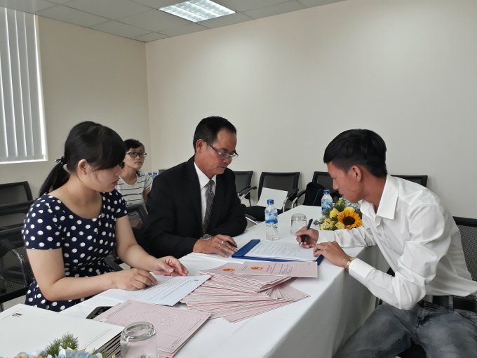 Doanh nghiệp v&agrave; người mua nh&agrave; k&yacute; hợp đồng nhận sổ hồng nh&agrave; chung cư.