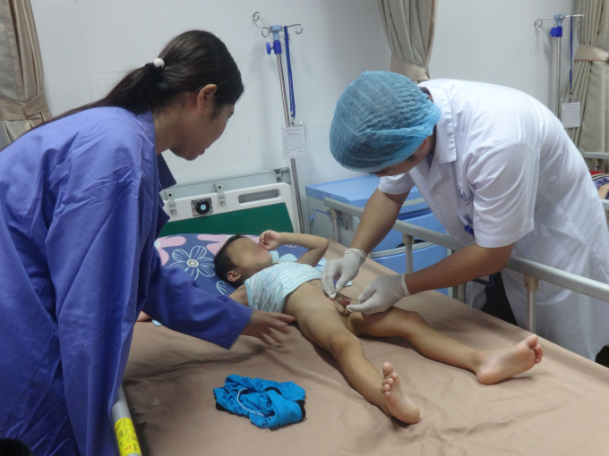 B&aacute;c sĩ thăm kh&aacute;m cho bệnh nhi mắc S&ugrave;i m&agrave;o g&agrave;. Ảnh: Ngọc Nga