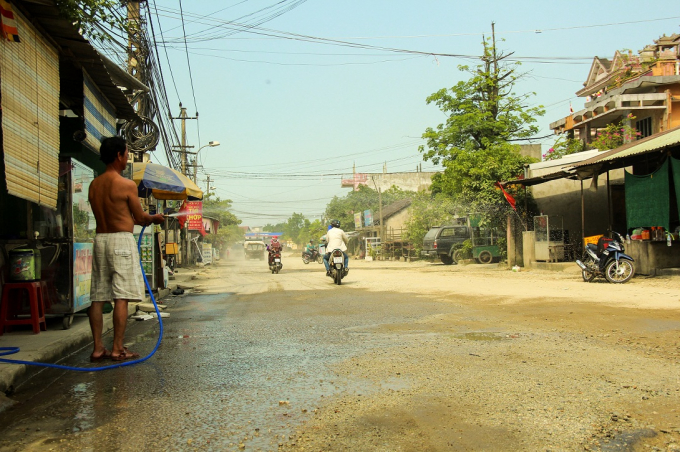 Những ng&agrave;y nắng th&igrave; bụi bay m&ugrave; mịt, người d&acirc;n phải xịt nước trước nh&agrave; để giảm bớt bụi.