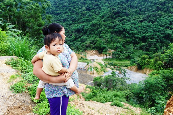 Người d&acirc;n x&oacute;m Khướng, x&atilde; Tự Do, huyện Lạc Sơn, tỉnh H&ograve;a B&igrave;nh đứng b&ecirc;n c&ocirc;ng tr&igrave;nh&nbsp;x&acirc;y nh&agrave; m&aacute;y thủy điện ngay dưới ch&acirc;n Th&aacute;c Mu. (Ảnh: H&ugrave;ng V&otilde;/Vietnam+)