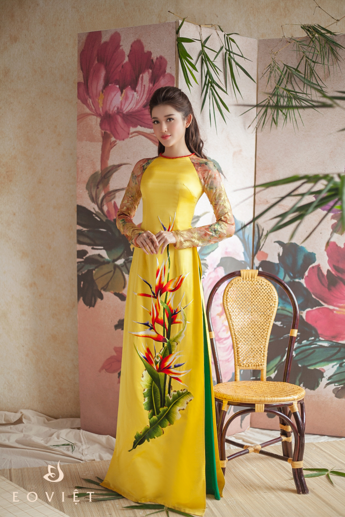 M&agrave;u v&agrave;ng l&agrave; gam m&agrave;u kh&oacute; mặc nhất, tuy nhi&ecirc;n với thiết kế cổ tr&ograve;n c&ugrave;ng với đường viền đỏ ở cổ v&agrave; sự ph&aacute; c&aacute;ch ở 2 t&agrave; c&aacute;nh tay đ&atilde; khiến chiếc &aacute;o d&agrave;i &ldquo;k&eacute;n người mặc&rdquo; mấy cũng trở n&ecirc;n mềm mại, dễ mặc hơn. Họa tiết hoa m&agrave;u đỏ l&agrave;m cho t&ocirc;ng v&agrave;ng trở n&ecirc;n dịu nhẹ hơn.