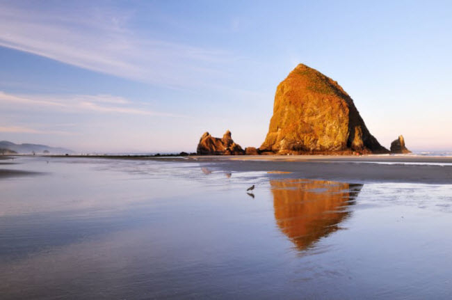 B&atilde;i biển Cannon Beach, Mỹ:C&aacute;ch th&agrave;nh phố Portland khoảng 90 ph&uacute;t di chuyển, b&atilde;i biển ở bang Oregon l&agrave; địa điểm kh&ocirc;ng thể bỏ qua đối với những người y&ecirc;u thi&ecirc;n nhi&ecirc;n. Bạn c&oacute; thể đi kh&aacute;m ph&aacute; v&agrave; chi&ecirc;m ngưỡng ngọn n&uacute;i Haystack Rock nằm ngo&agrave;i biển.