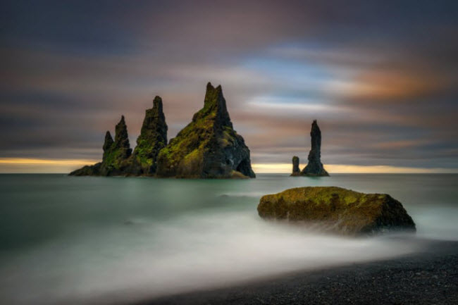 B&atilde;i biển Reynisfjara, Iceland: V&agrave;o m&ugrave;a đ&ocirc;ng, bạn c&oacute; thể chứng kiến hiện tượng m&acirc;y cuộn tr&ecirc;n b&atilde;i biển c&aacute;t đen n&agrave;y.