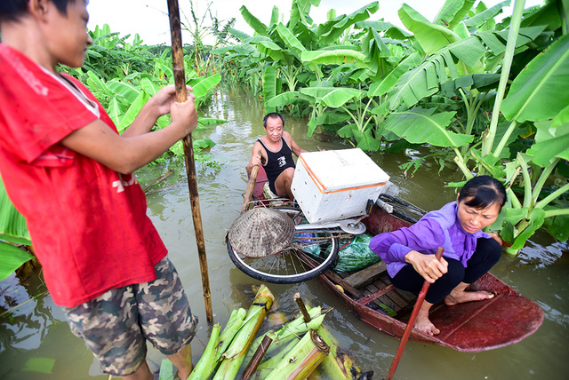 Lương chống b&egrave; đi qua thuyền của một gia đ&igrave;nh kh&aacute;c ở b&atilde;i giữa.