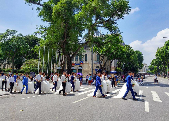 C&ocirc; d&acirc;u, ch&uacute; rể tay trong tay dạo bước tr&ecirc;n phố đi bộ quanh Hồ Gươm trong tiết trời nắng đẹp.