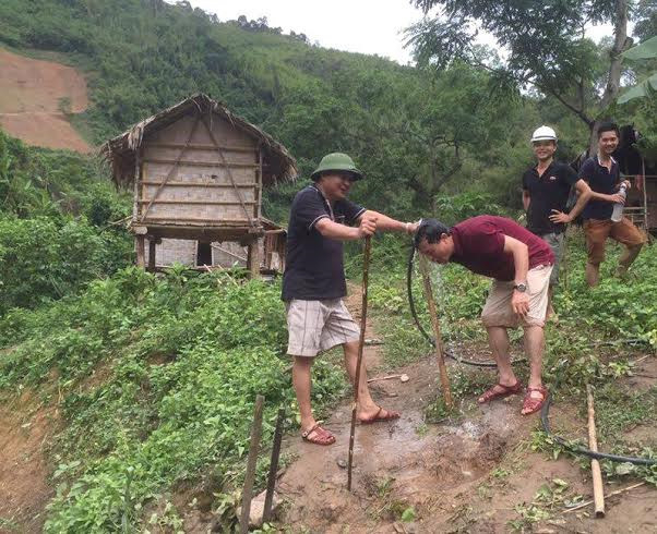 Tướng Hồ Sỹ Tiến (mũ cối) gi&uacute;p đồng đội trong chuyến c&ocirc;ng t&aacute;c.