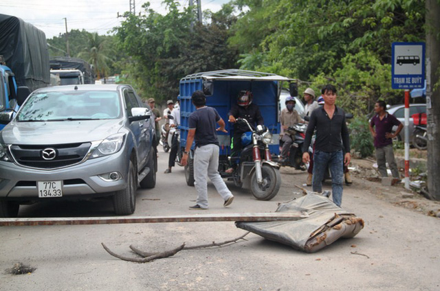 Bức x&uacute;c v&igrave; từng đo&agrave;n xe tải chạy g&acirc;y bụi, d&acirc;n đem c&acirc;y chặn đường cấm xe tải lưu th&ocirc;ng.
