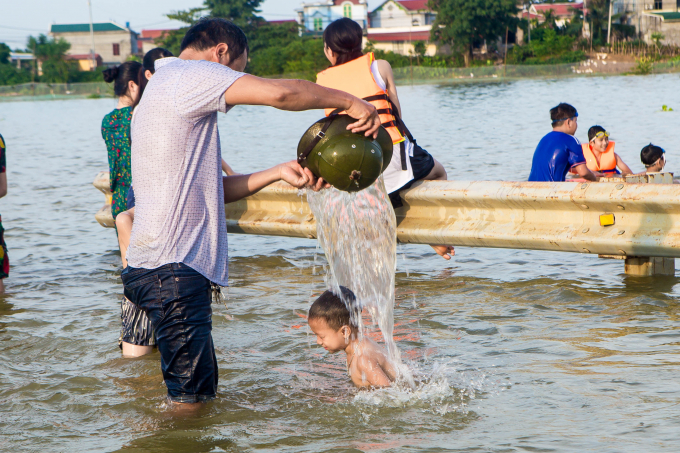 Sau 2 ng&agrave;y, lượng nước đ&atilde; giảm đi, chỗ s&acirc;u nhất cũng chỉ c&ograve;n khoảng 60cm n&ecirc;n nhiều gia đ&igrave;nh cho c&aacute;c em nhỏ ra đ&acirc;y chơi đ&ugrave;a.
