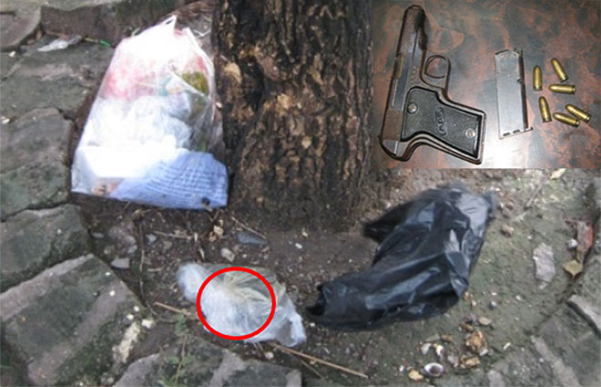 Khẩu s&uacute;ng qu&acirc;n dụng v&agrave; 6 vi&ecirc;n đạn được đựng trong bọc nilon để b&ecirc;n gốc c&acirc;y ven đường.