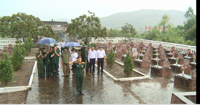 Trời mưa như tr&uacute;t nước, nữ chiến sĩ đội mưa tri &acirc;n c&aacute;c anh h&ugrave;ng liệt sỹ theo nghi thức qu&acirc;n đội.