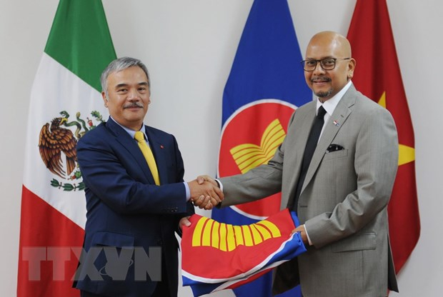Đại sứ Việt Nam Nguyễn Hoài Dương trao cờ ASEAN cho Đại sứ Indonesia Cosmas Cheppy Tri Prakoso Wartono. (Ảnh: Việt Hùng/TTXVN)