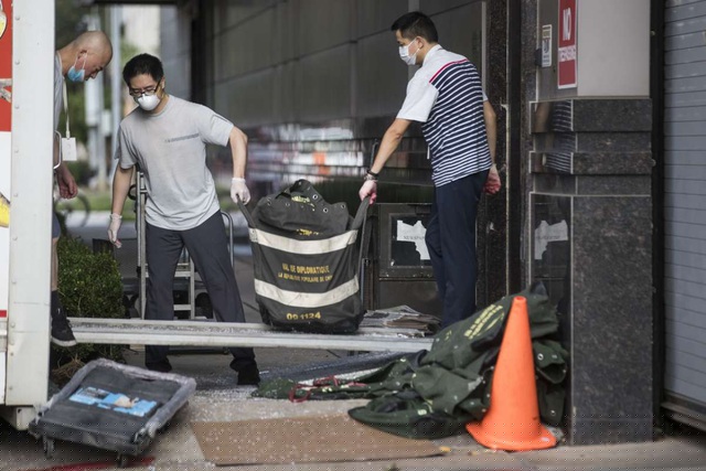 Nh&acirc;n vi&ecirc;n l&atilde;nh sự qu&aacute;n Trung Quốc dọn đồ đi. (Ảnh: Houston Chronicle)