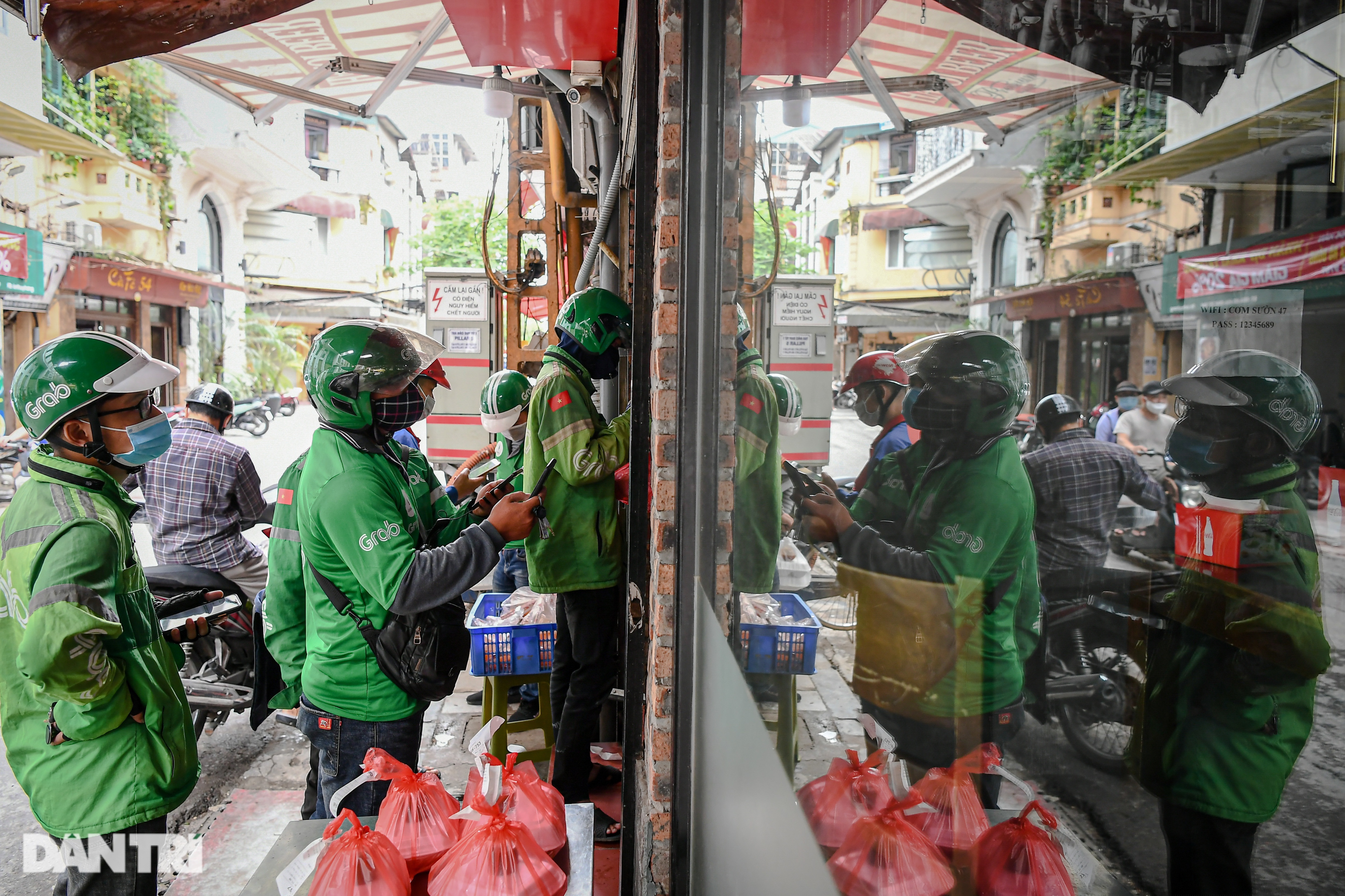 Các shipper chờ lấy đơn tại một cửa hàng (Ảnh: Đỗ Linh).