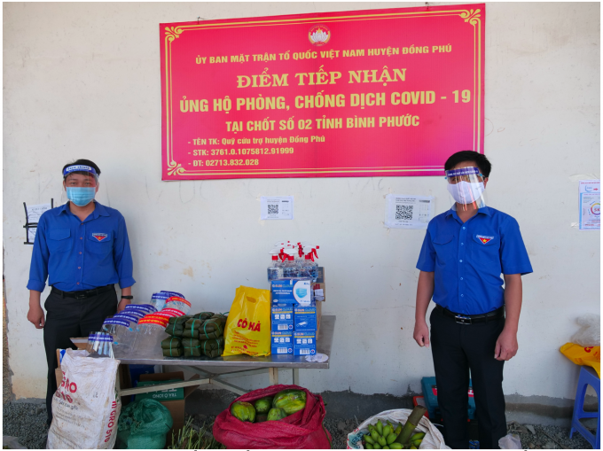 Bí thư Tỉnh Đoàn Trần Quốc Duy (bên phải) trao tặng rau, củ, quả tại chốt kiểm soát giao thông số 2 của tỉnh tại xã Tân Lập (H.Đồng Phú)