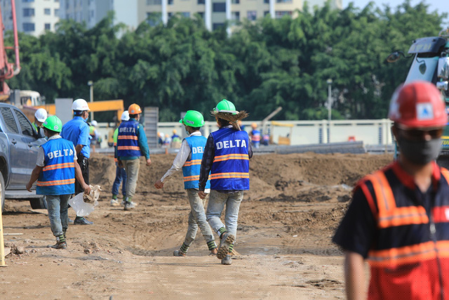 Các công nhân cùng các phương tiện cơ giới đang gấp rút thi công để đưa bệnh viện vào sử dụng.