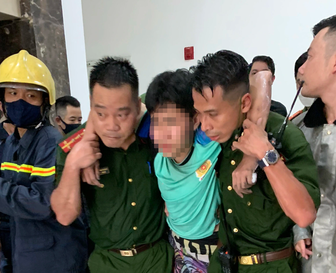 Lực lượng chức năng đưa cháu bé ra khỏi căn hộ bị cháy.