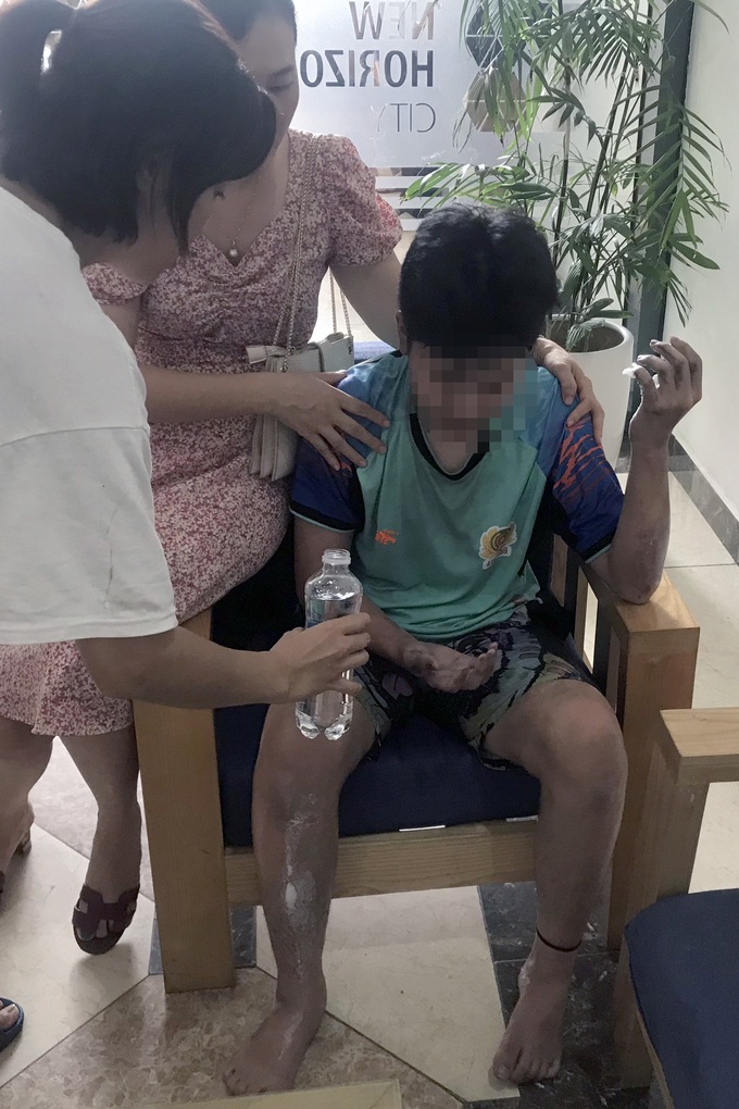 Bé trai được giải cứu, đưa ra ngoài an toàn, thay quần áo, sơ cứu vết bỏng (Ảnh: Công an Hà Nội).