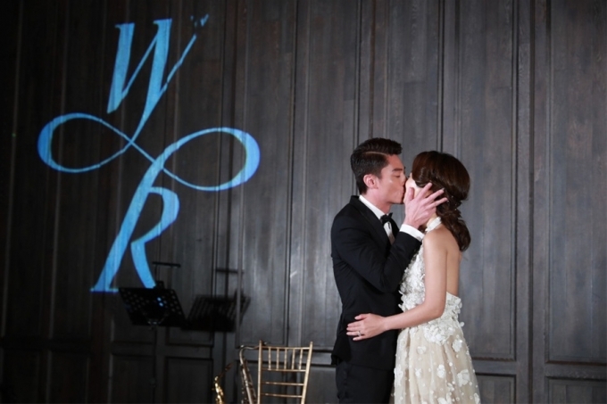 Cặp đ&ocirc;i hạnh ph&uacute;c trao nhau nụ h&ocirc;n trong bữa tiệc.