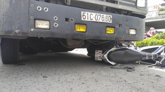 Chiếc xe m&aacute;y nằm dưới b&aacute;nh xe container