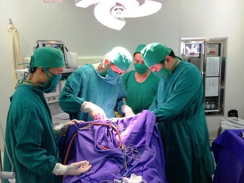 C&aacute;c b&aacute;c sĩ đang tiến h&agrave;nh phẫu thuật cho b&eacute; bị dao quắm xuy&ecirc;n tr&aacute;n. Ảnh: VnExpress