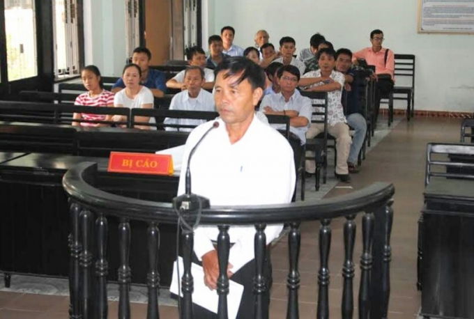 &Ocirc;ng Nguyễn Văn Quyền cầm nhiều hồ sơ, giấy tờ cho rằng m&igrave;nh v&ocirc; tội trước phi&ecirc;n t&ograve;a.