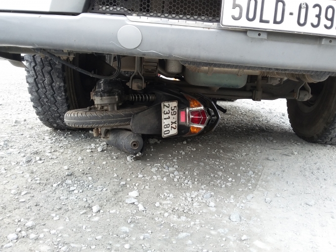 Chiếc xe m&aacute;y kẹt cứng dưới gầm container