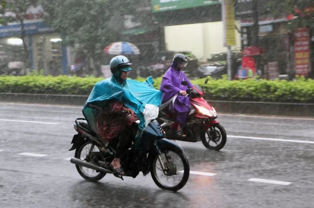 Người H&agrave; Nội trang bị 2 &aacute;o mưa, vội v&atilde; trở về nh&agrave; trong mưa b&atilde;o. (Ảnh: Qu&yacute; Đo&agrave;n)