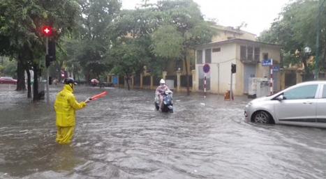 Nh&acirc;n vi&ecirc;n tho&aacute;t nước v&agrave; c&ocirc;ng việc quen thuộc mỗi khi trời mưa. (Ảnh: Tiến Nguy&ecirc;n)