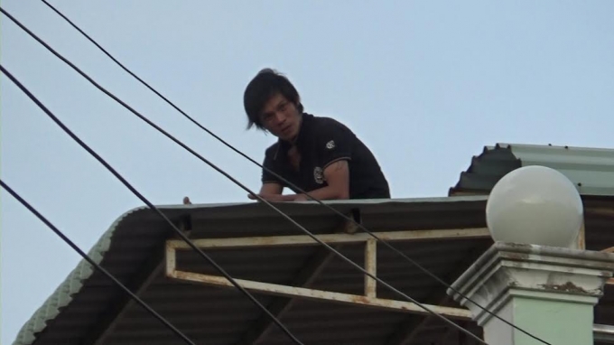 Nam thanh ni&ecirc;n cố thủ tr&ecirc;n n&oacute;c nh&agrave; nhiều giờ.