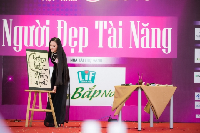 Ho&agrave;ng Thị Quỳnh Loan (SBD 128)&nbsp;khoe t&agrave;i viết thư ph&aacute;p tr&ecirc;n nền nhạc h&agrave;o h&ugrave;ng của ca kh&uacute;c &ldquo;D&ograve;ng m&aacute;u Lạc Hồng&rdquo;.mặc &aacute;o d&agrave;i đen khoe nhan sắc đậm chất cố đ&ocirc; cuốn h&uacute;t khi viết chữ