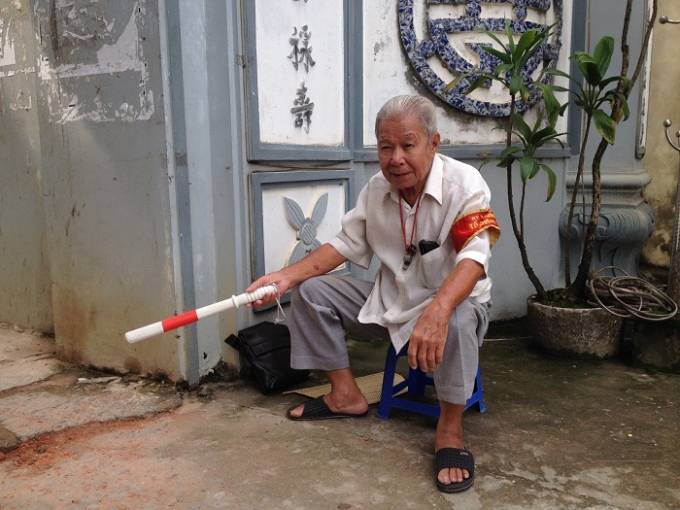 D&ugrave; trời nắng hay trời mưa, &ocirc;ng Ch&iacute;nh vẫn lu&ocirc;n ra đứng đầu cổng l&agrave;ng điều tiết giao th&ocirc;ng. Ảnh: Thảo Nguy&ecirc;n.