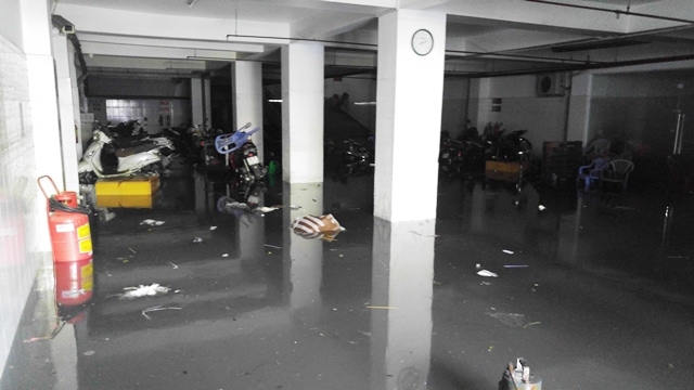 Tại chi nh&aacute;nh một ng&acirc;n h&agrave;ng nằm tr&ecirc;n đường Phan X&iacute;ch Long, 8h30 s&aacute;ng 27/8 (hơn 12 giờ sau khi xảy ra mưa lớn) tầng hầm của t&ograve;a nh&agrave; n&agrave;y vẫn ngập s&acirc;u hơn nửa b&aacute;nh xe m&aacute;y.
