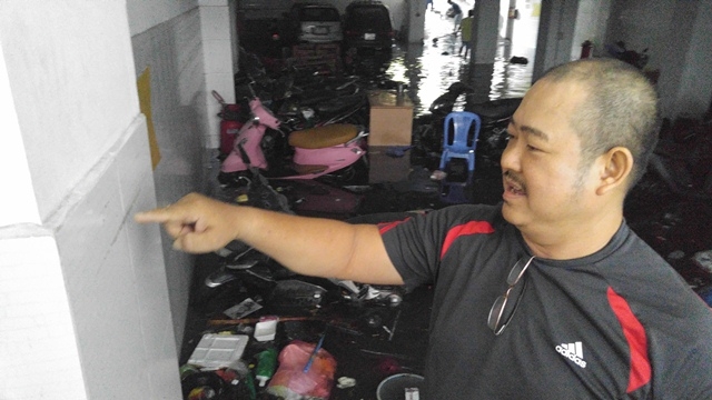 Anh Sơn, chủ đại l&yacute; gạo chỉ tay v&agrave;o vệt nước tr&ecirc;n tường tầng hầm v&agrave; cho biết: Mưa qu&aacute; lớn khiến tầng hầm của PV Bank biến th&agrave;nh bể bơi.