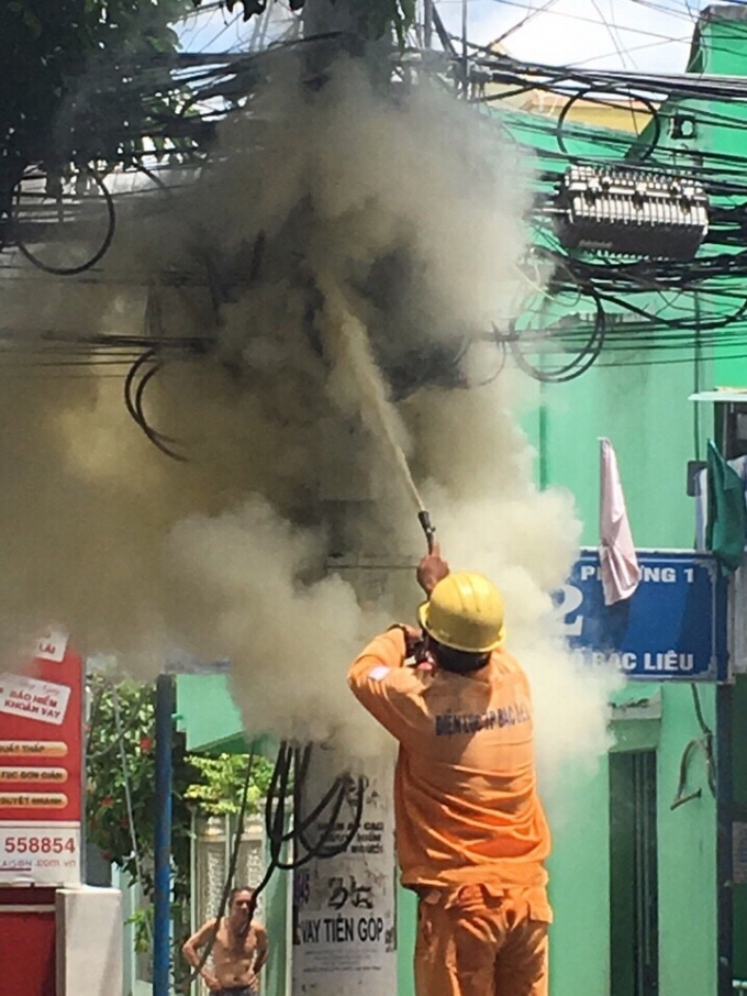 Nh&acirc;n vi&ecirc;n điện lực Bạc Li&ecirc;u d&ugrave;ng b&igrave;nh cứu hỏa dập tắt đ&aacute;m ch&aacute;y.