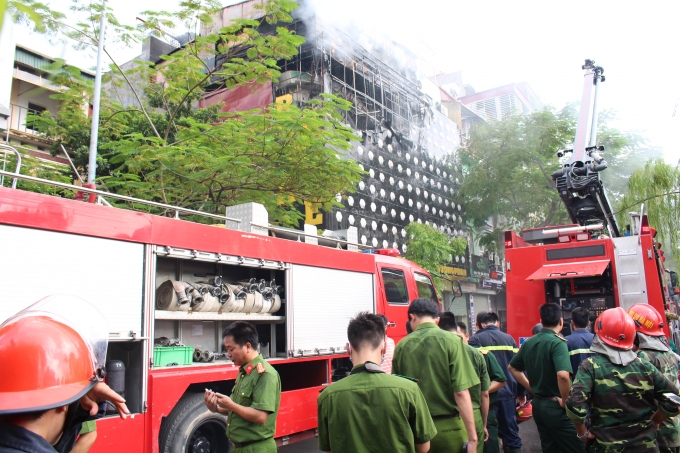 Từng mảng lửa rơi xuống từ qu&aacute;n Karaoke khiến người đi đường th&oacute;t tim