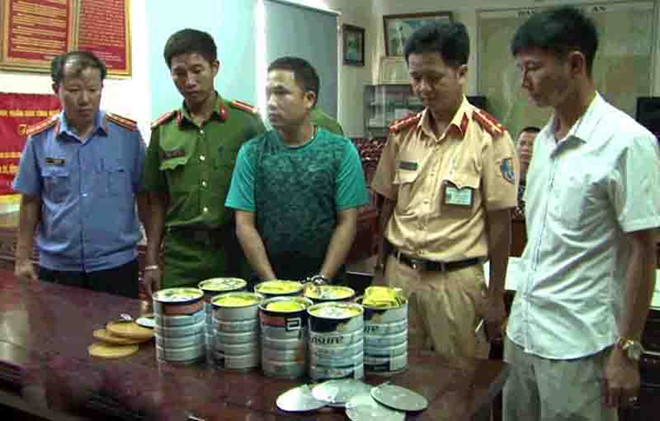 Mai Đ&igrave;nh Phước (đứng giữa) c&ugrave;ng tang vật chuy&ecirc;n &aacute;n. (Ảnh: Zing.vn)