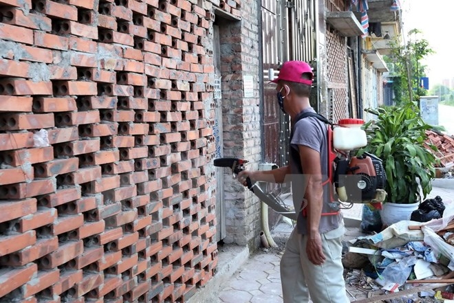 Nh&acirc;n vi&ecirc;n Trạm y tế dự ph&ograve;ng phường T&acirc;n Triều (huyện Thanh Tr&igrave;) phun thuốc diệt muỗi đợt 2 cho c&aacute;c hộ gia đ&igrave;nh tr&ecirc;n địa b&agrave;n phường T&acirc;n Triều. (Ảnh: Quang Quyết/TTXVN)