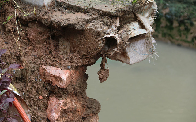 Phần đất đ&aacute; tiếp tục sạt xuống mương tho&aacute;t nước.