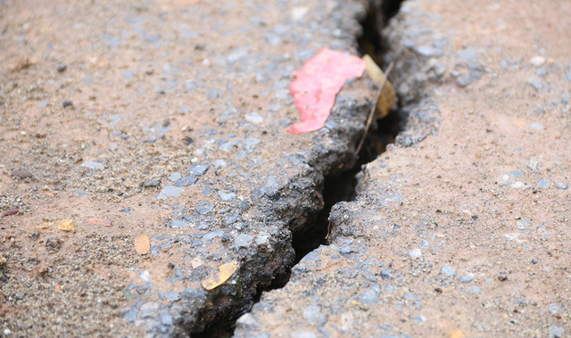 Nhiều vết nứt lớn v&agrave; k&eacute;o d&agrave;i xuất hiện tr&ecirc;n đường nhựa ngay cạnh đoạn bị sạt lở.