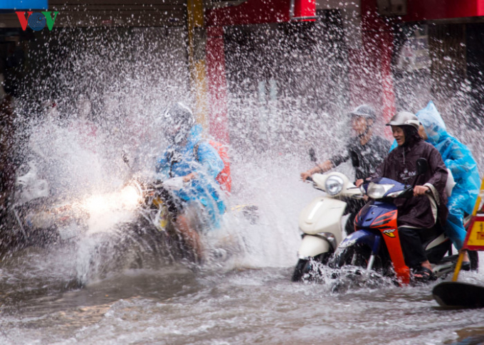 Người H&agrave; Nội vẫn phải lao m&igrave;nh ra đường trong mưa.&nbsp;(Ảnh:VOV)