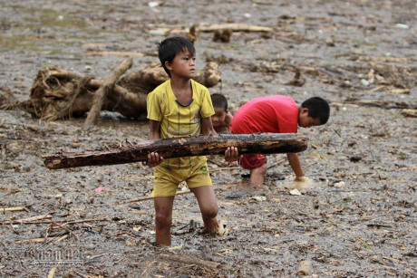 Trẻ em M&ugrave; Cang Chải đi vớt củi tr&ecirc;n hồ thủy điện Mồ Dề sau lũ. Ảnh: Đo&agrave;n Bổng